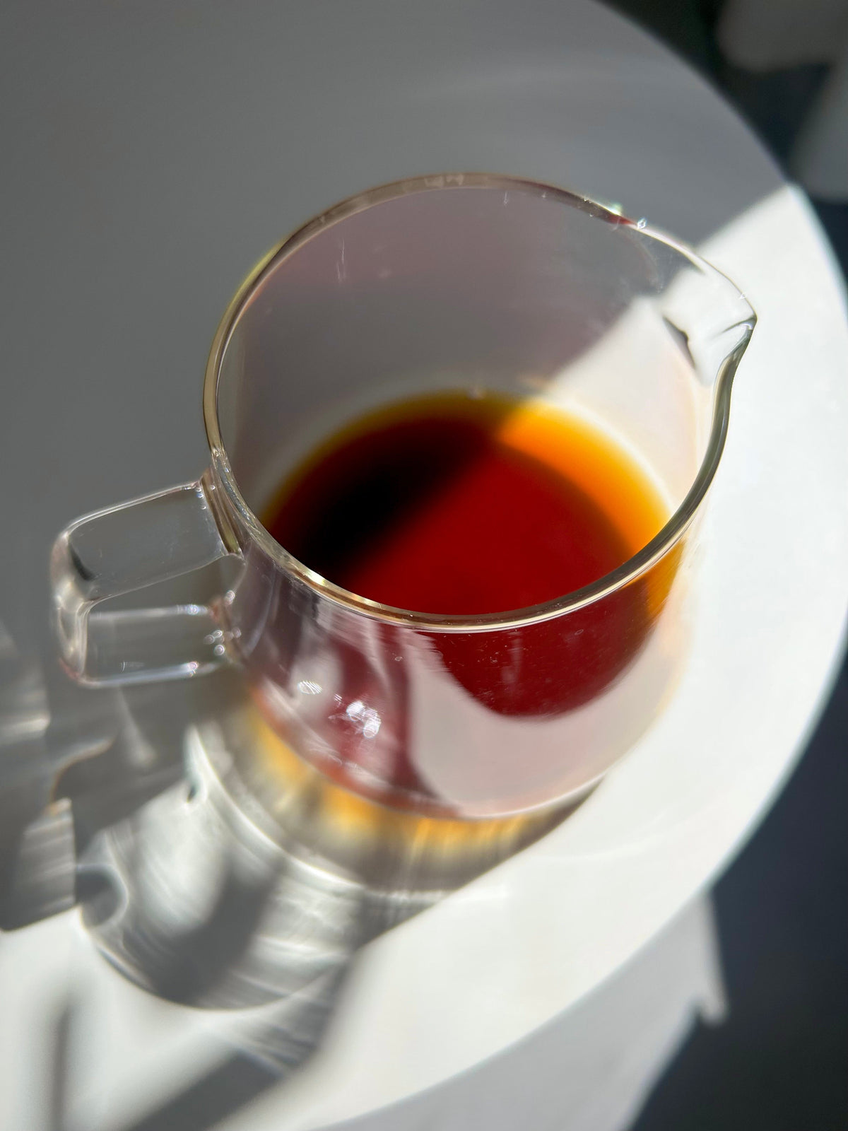Clear glass Kinto server carafe filled with brewed filter coffee by Interpret Coffee Roasters.